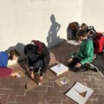 children making cardboard sundials outdoors